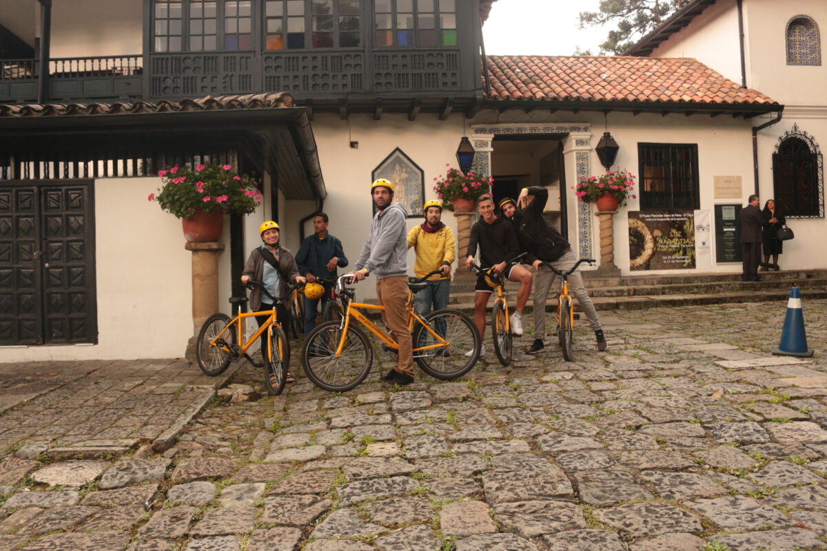 Travelers with bicycles outside a colonial building in La Candelaria, Bogotá, Colombia