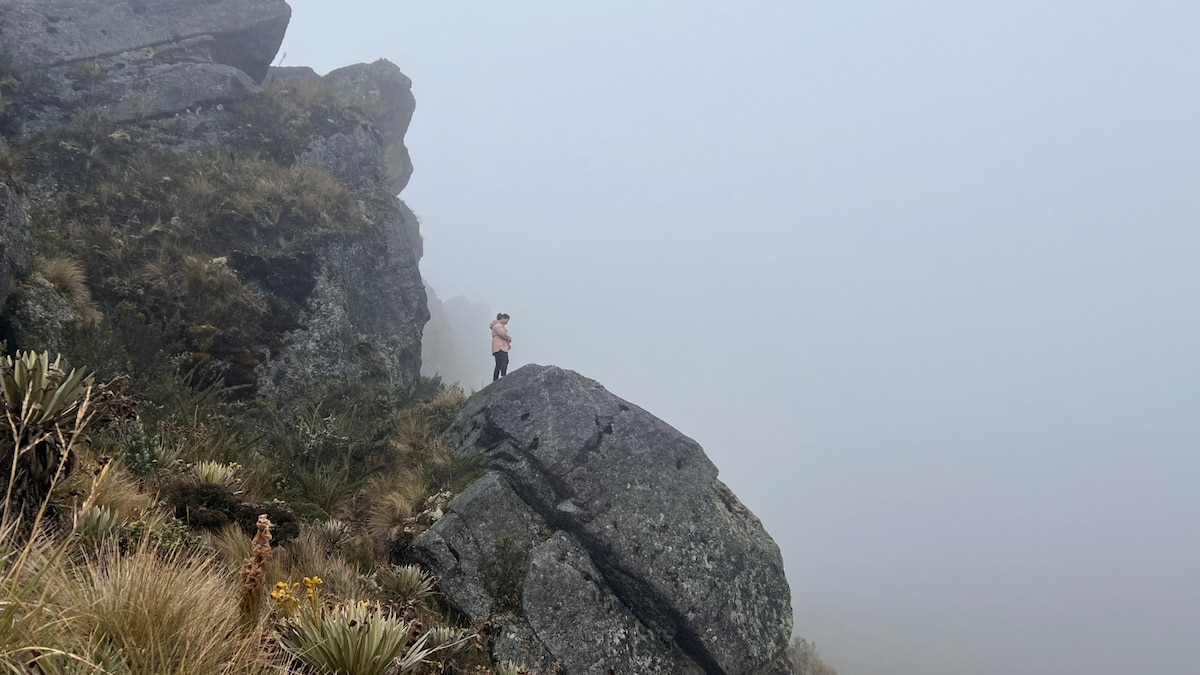 Traveler standing on a rocky viewpoint in Sumapaz Páramo, Colombia