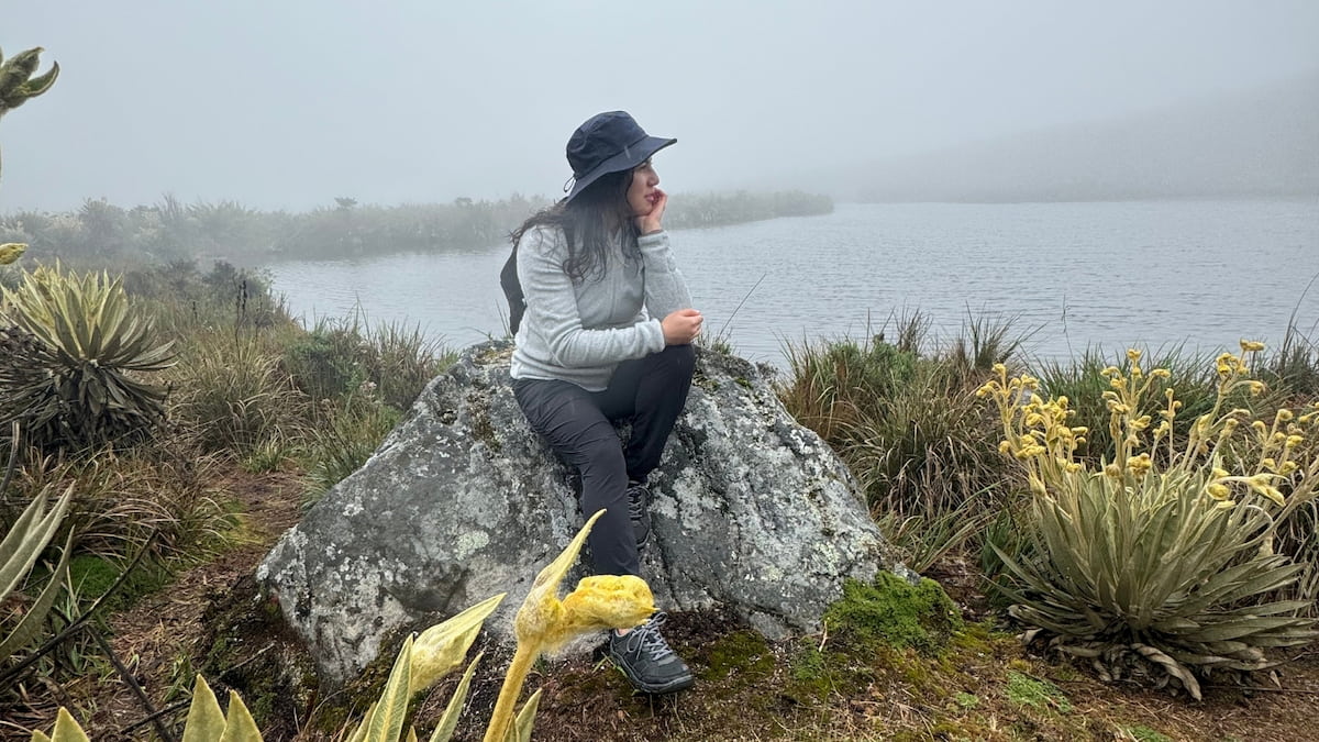 Traveler resting beside a lagoon in Sumapaz Páramo, Colombia