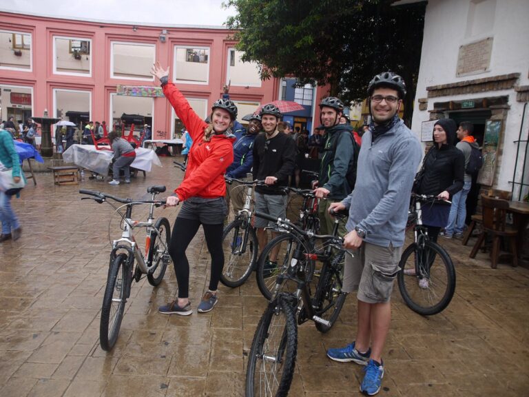 Travelers posing with bicycles in La Candelaria, Bogotá, Colombia