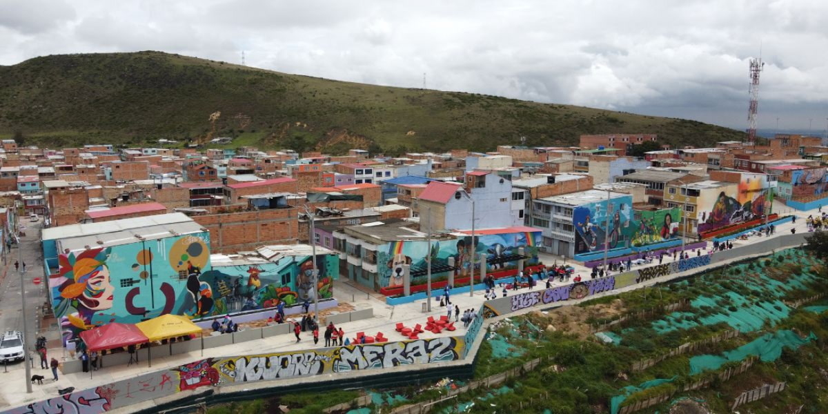 Panoramic view of street art and hillside homes on the El Paraíso Favela Tour in Ciudad Bolívar, Bogotá, Colombia.