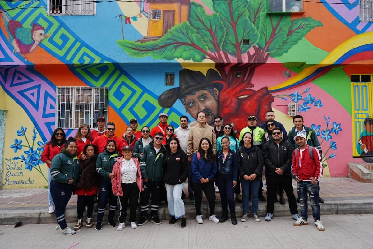 Community group posing in front of a mural in El Paraíso, Ciudad Bolívar, Bogotá, Colombia.