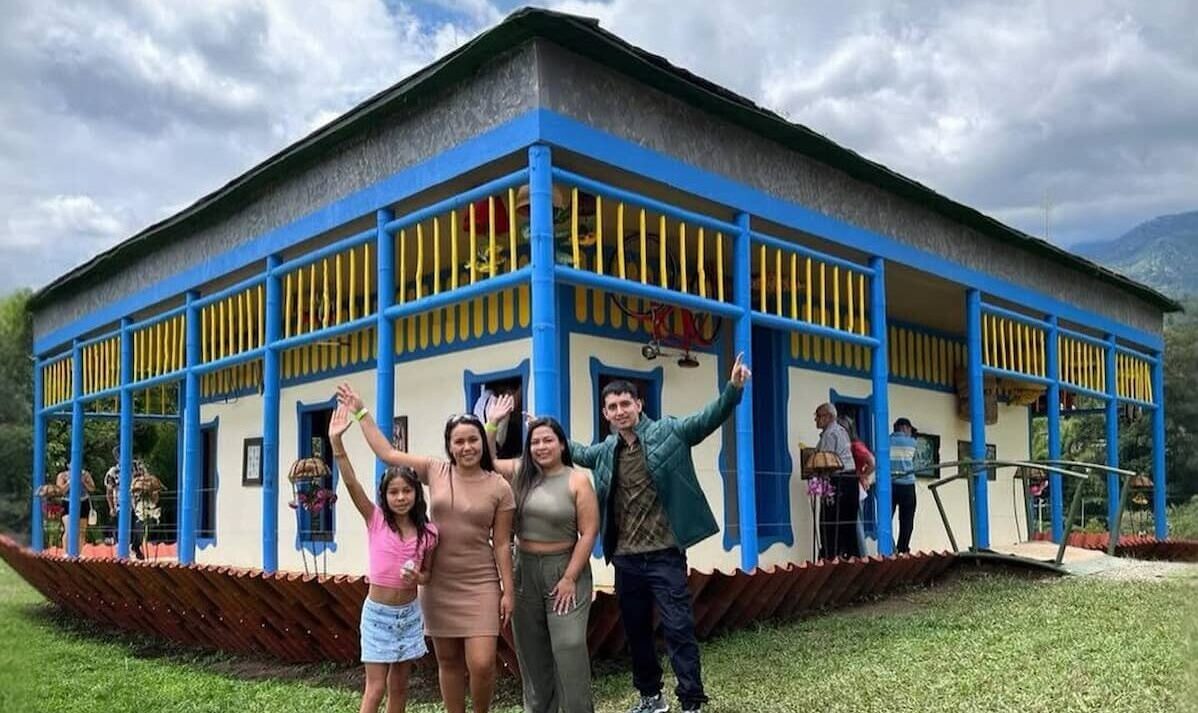 Family posing in front of a colorful farmhouse at a coffee farm in Quindío, Colombia