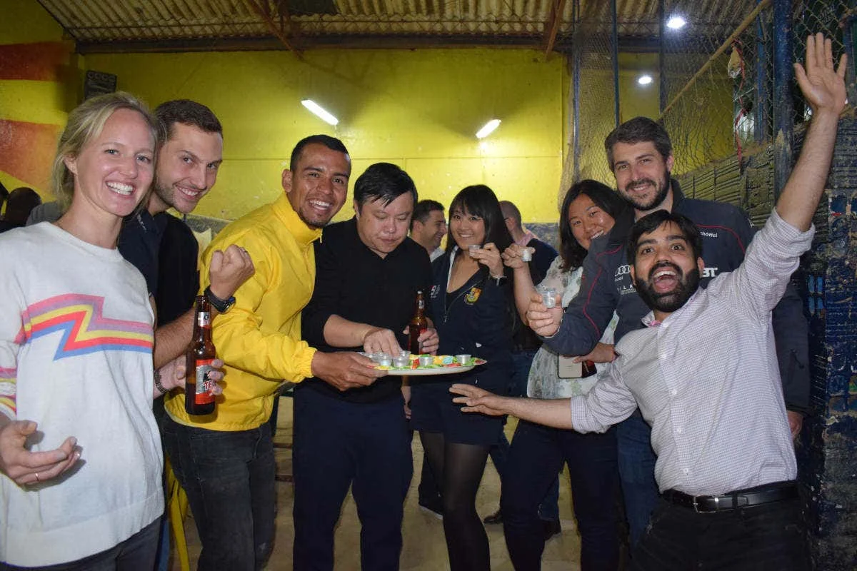 Group celebrating with drinks after playing tejo at La Embajada in Bogotá, Colombia.