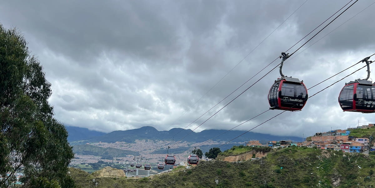 TransMiCable cabins crossing the hills of El Paraíso in Ciudad Bolívar, Bogotá, Colombia.
