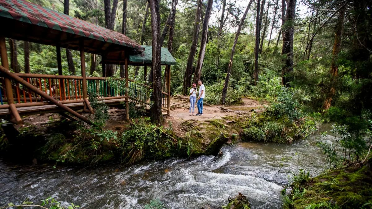 Couple standing by a river in Parque Arví, Medellín, Colombia