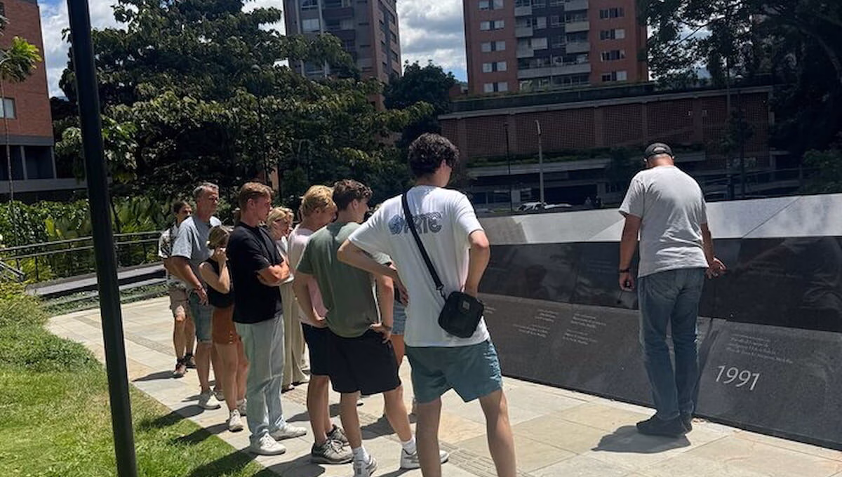 Travelers listening to a guide at Inflexion Memorial Park in Medellín, Colombia.
