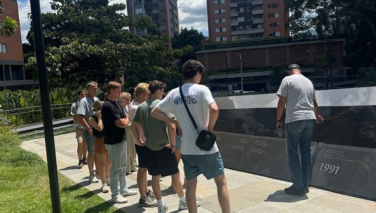 Travelers listening to a guide at Inflexion Memorial Park in Medellín, Colombia.
