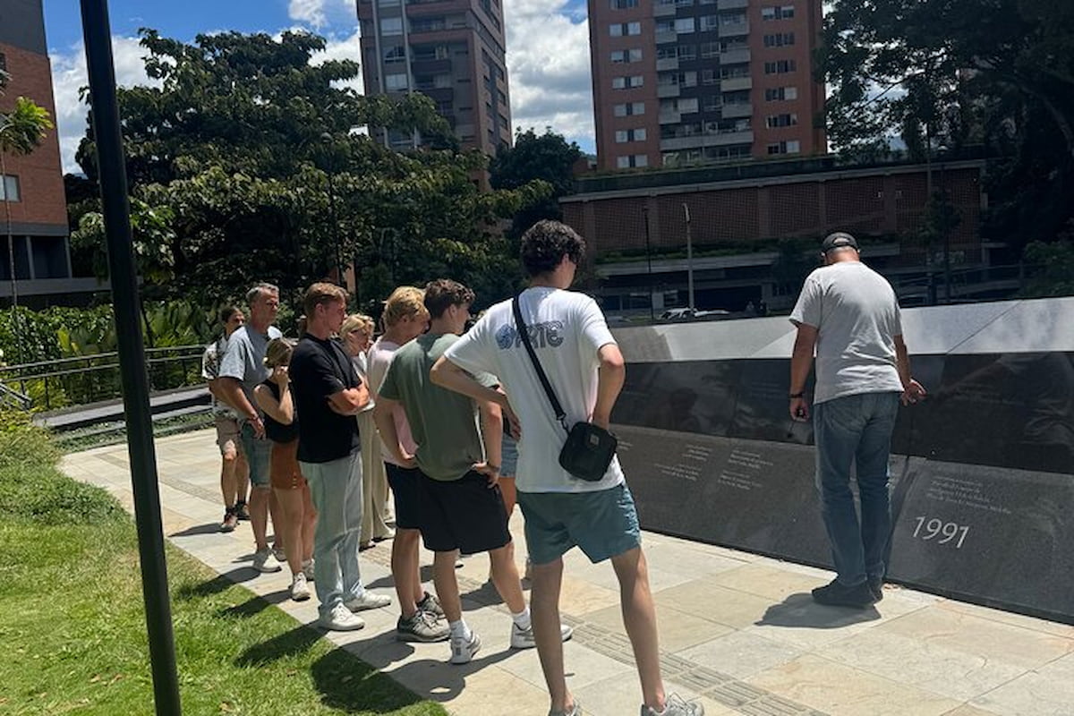 Travelers listening to a guide at Inflexion Memorial Park in Medellín, Colombia.