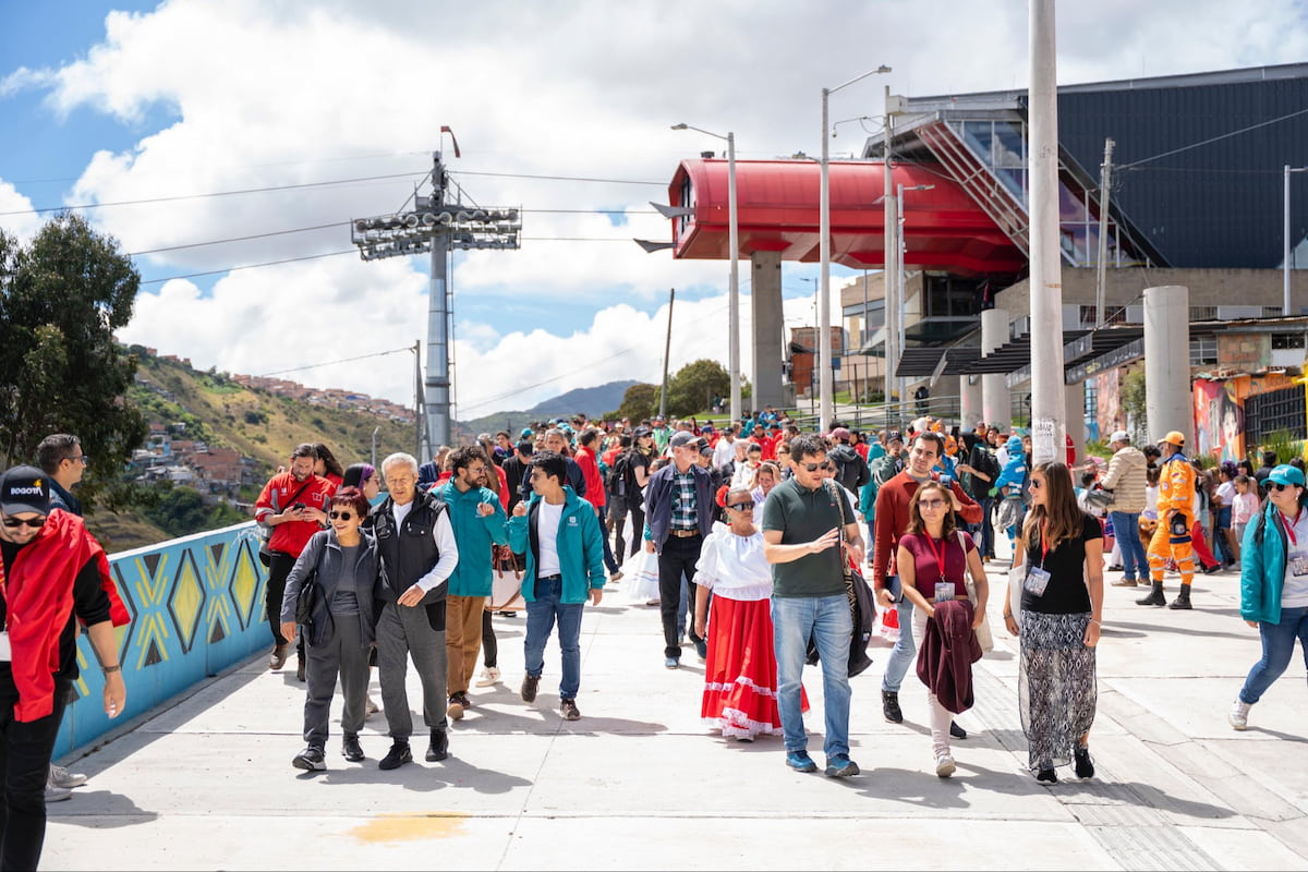 Visitors walking near the TransMiCable station on the El Paraíso Favela Tour in Ciudad Bolívar, Bogotá, Colombia.
