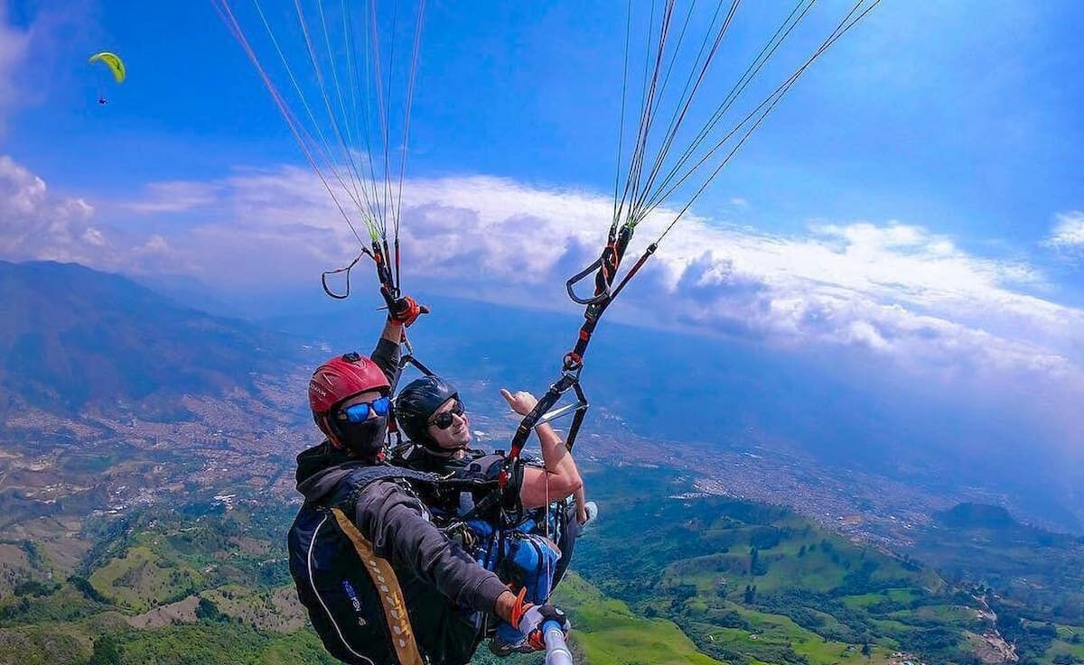 Traveler enjoying paragliding in Medellín with panoramic valley views, Colombia