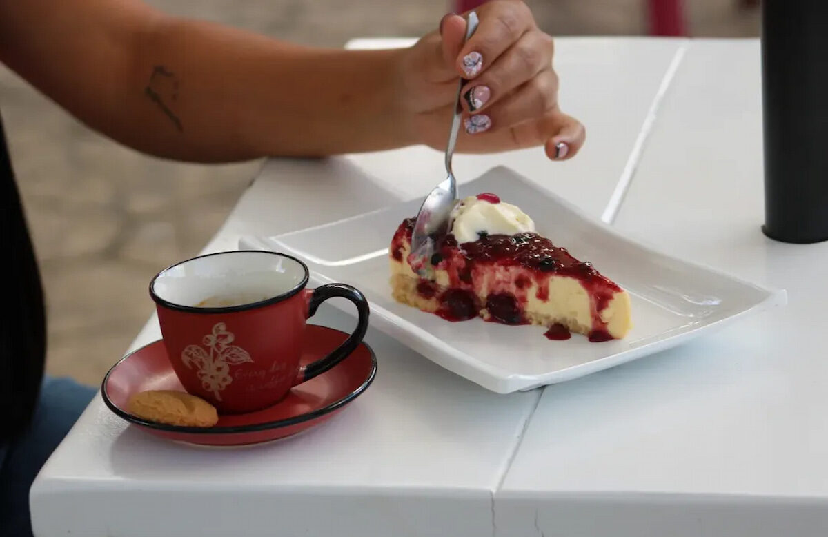 Traveler eating cheesecake with coffee at a café in Buenavista, Quindío, Colombia