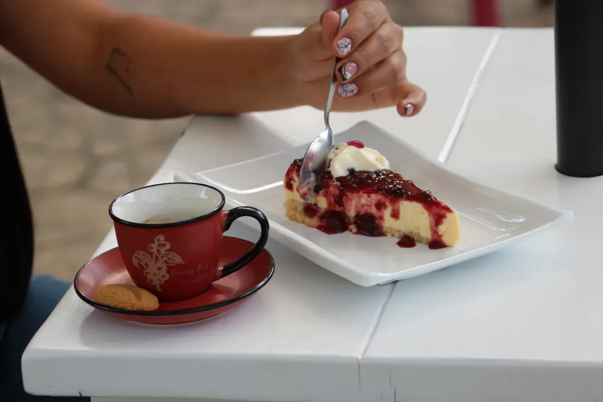 Traveler eating cheesecake with coffee at a café in Buenavista, Quindío, Colombia
