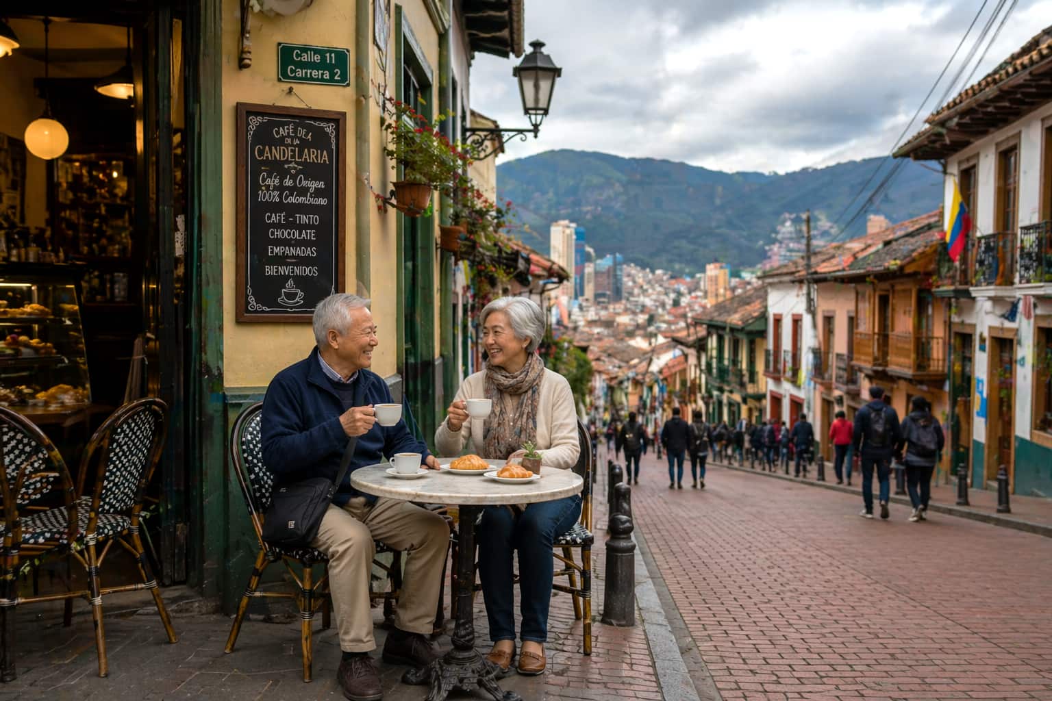 older couple sitting at a small café table on a hillside street overlooking Bogotá cityscape Colombia