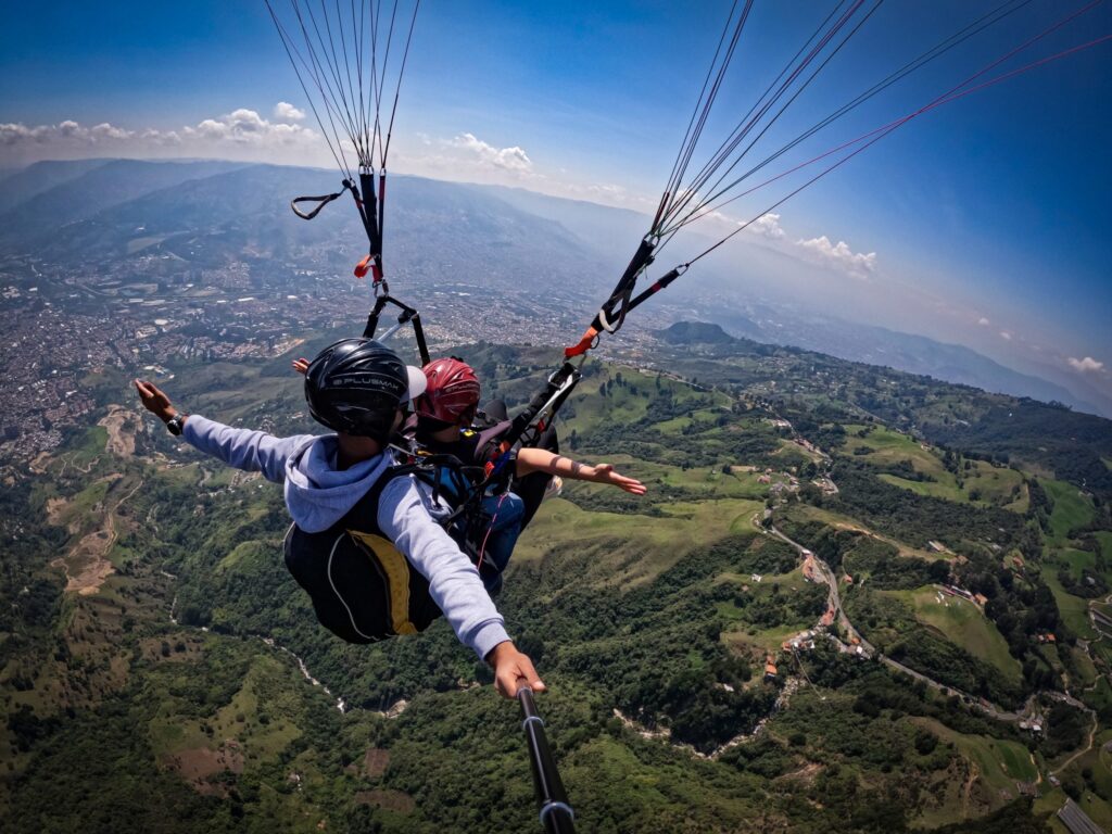 Couple paragliding in Medellín above the mountains and valley, Colombi