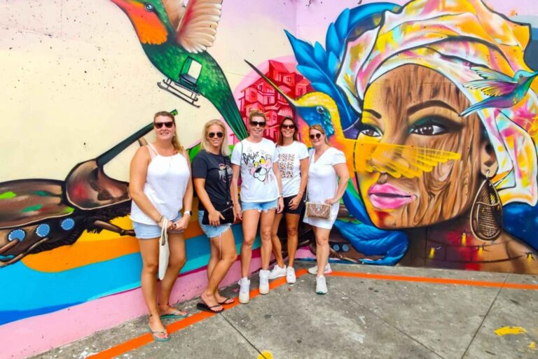 Travelers in front of a mural on a graffiti tour of Comuna 13, Medellín