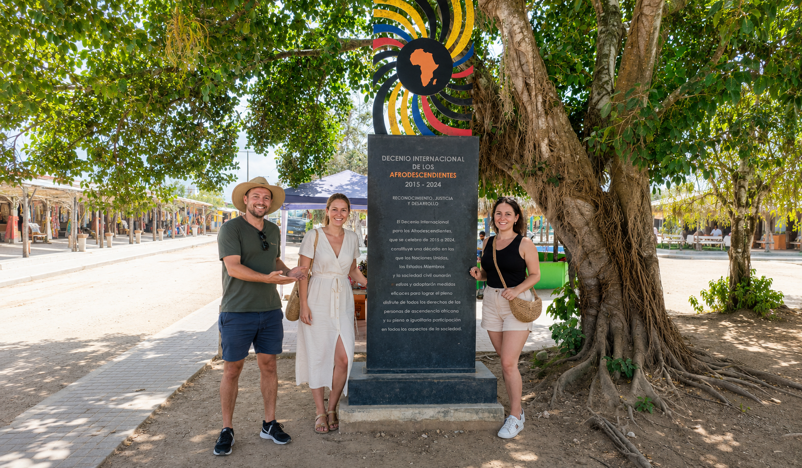 Travelers posing beside an Afro-descendant heritage monument during a San Basilio de Palenque tour.