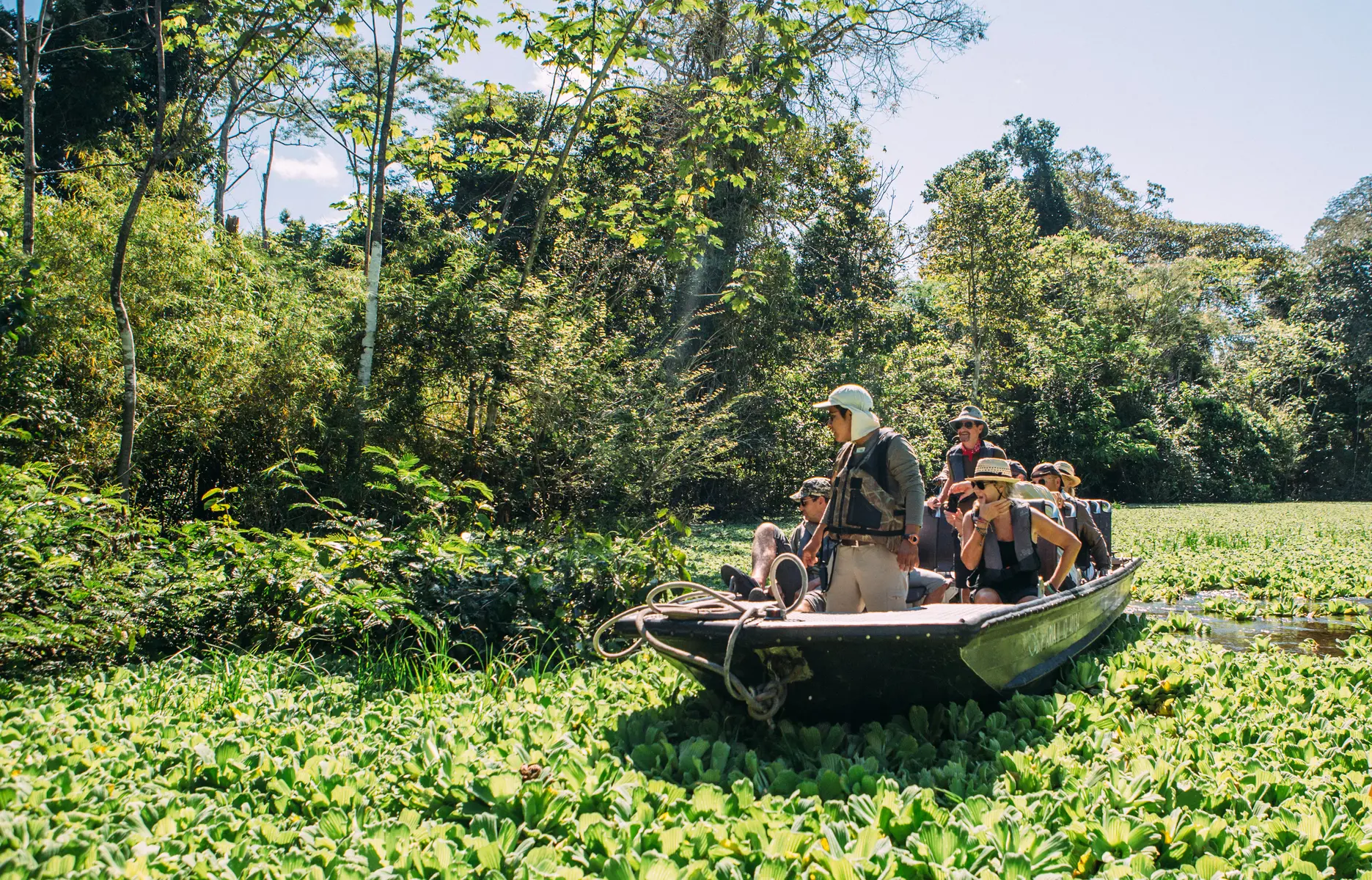 Travelers exploring the Amazon by boat through lush waterways on a Birding Amazon Tour.