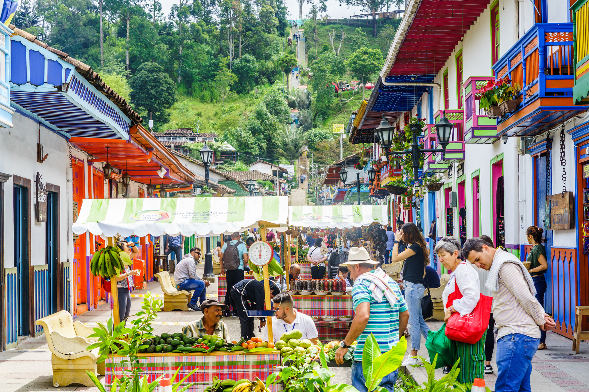 Bustling street market with colorful balconies and local produce in Filandia, captured on a Coffee Town Tour.
