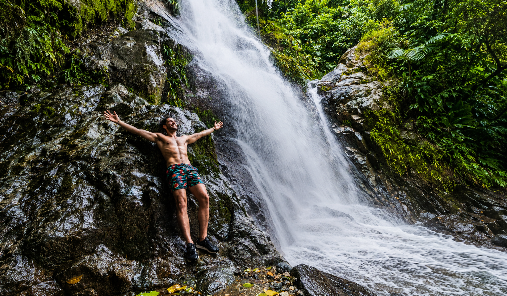 Traveler standing beside a tropical waterfall on an adventurous La Guajira waterfall tour.