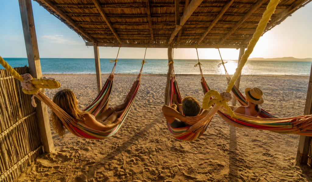 Travelers relaxing in colorful hammocks facing the ocean during the 3 day tour La Guajira.