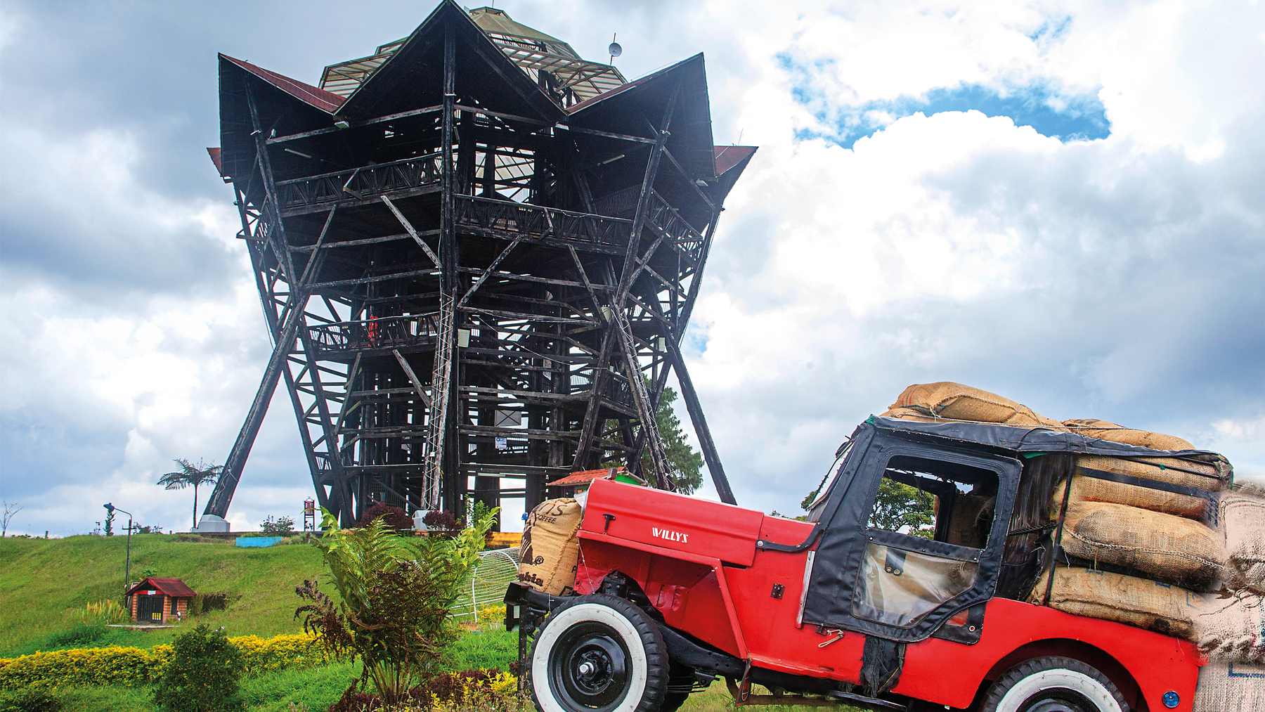 Traditional jeep loaded with coffee sacks beside the Filandia viewpoint on a scenic Coffee Town Tour.