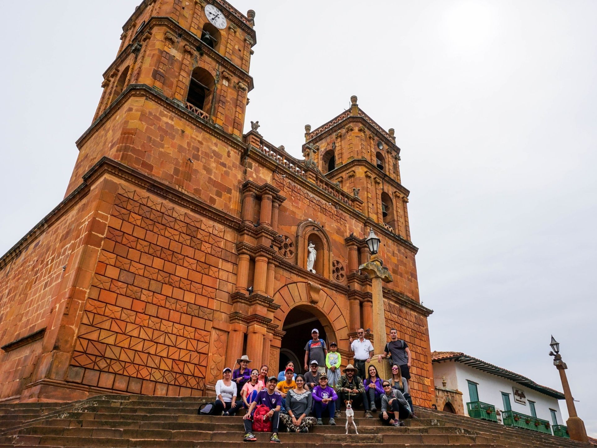 Group posing on the steps of Barichara Cathedral, a highlight of a Barichara Tour.