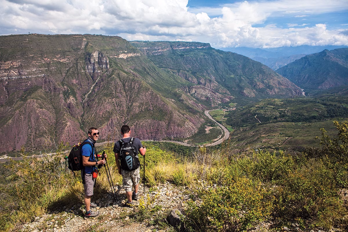Travelers admiring the breathtaking canyon panorama from a lookout on a Chicamocha National Park Tour.