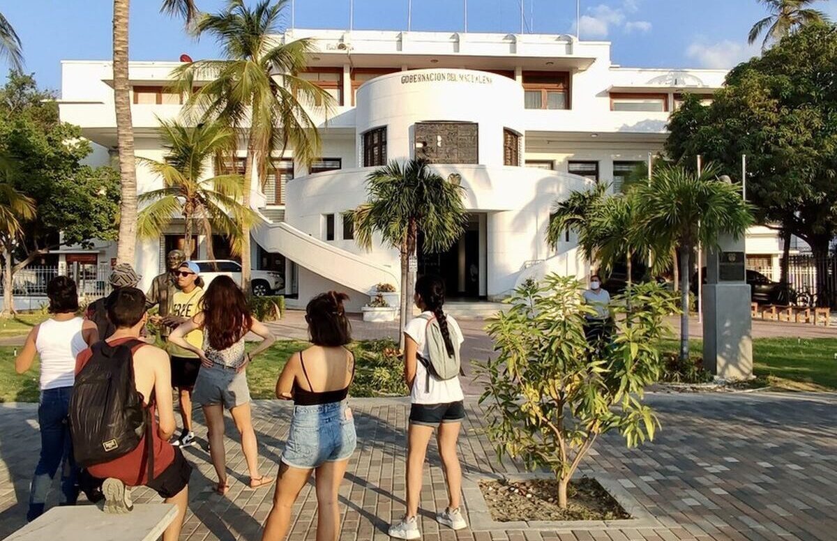 Visitors listening to their guide outside the Government Palace during a Santa Marta City Tour.