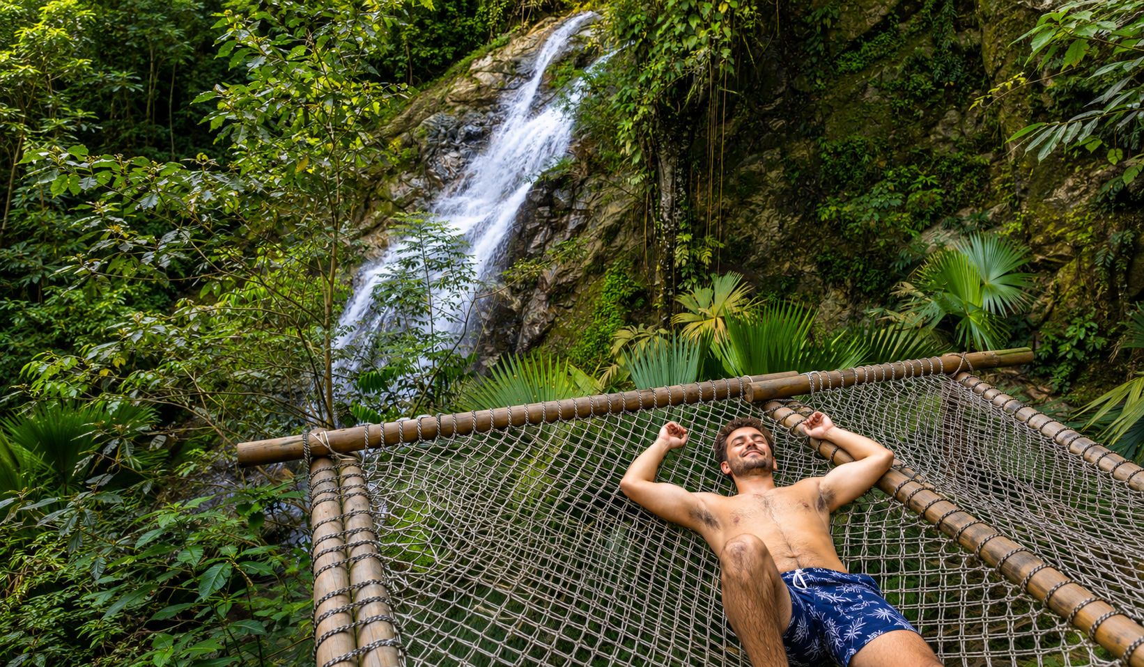Man relaxing on a hammock with a waterfall view during a La Guajira waterfall tour.