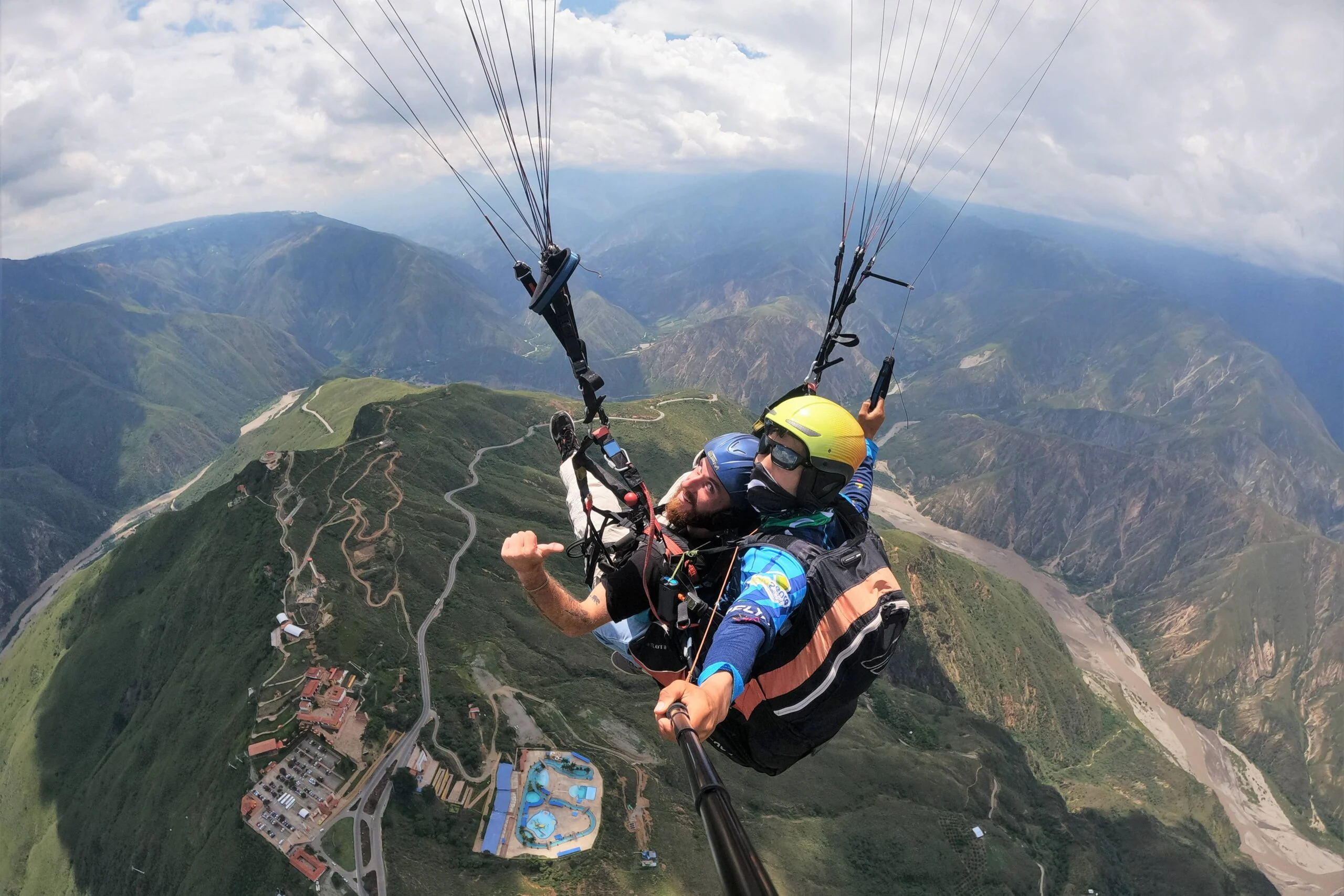 Tandem paragliding adventure with sweeping views of winding roads and canyon cliffs in Chicamocha Canyon.