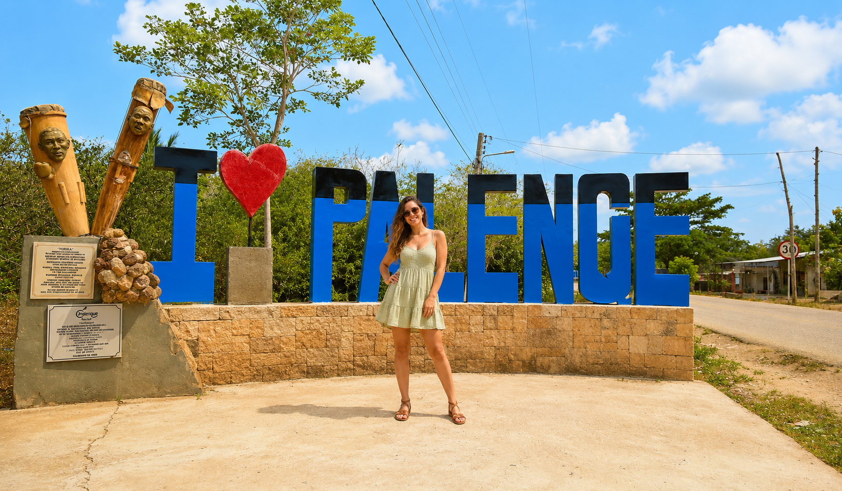 Traveler posing in front of the I Love Palenque sign on a San Basilio de Palenque tour.