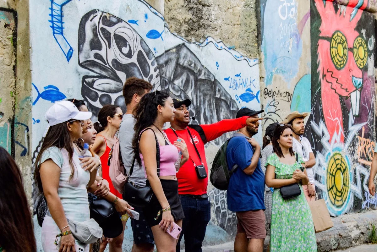 Guide showing murals to visitors during a Graffiti Tour in Cartagena, Colombia