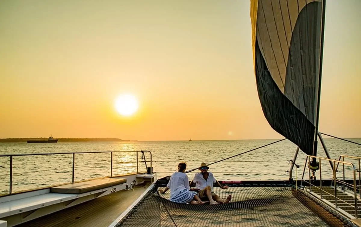 Couple relaxing on a catamaran net during a cartagena sunset boat tour private experience on the Caribbean Sea.