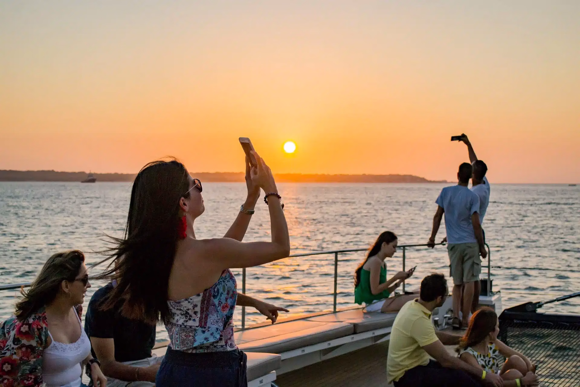Guests enjoying the ocean breeze and sunset views on a cartagena sunset boat tour private experience.