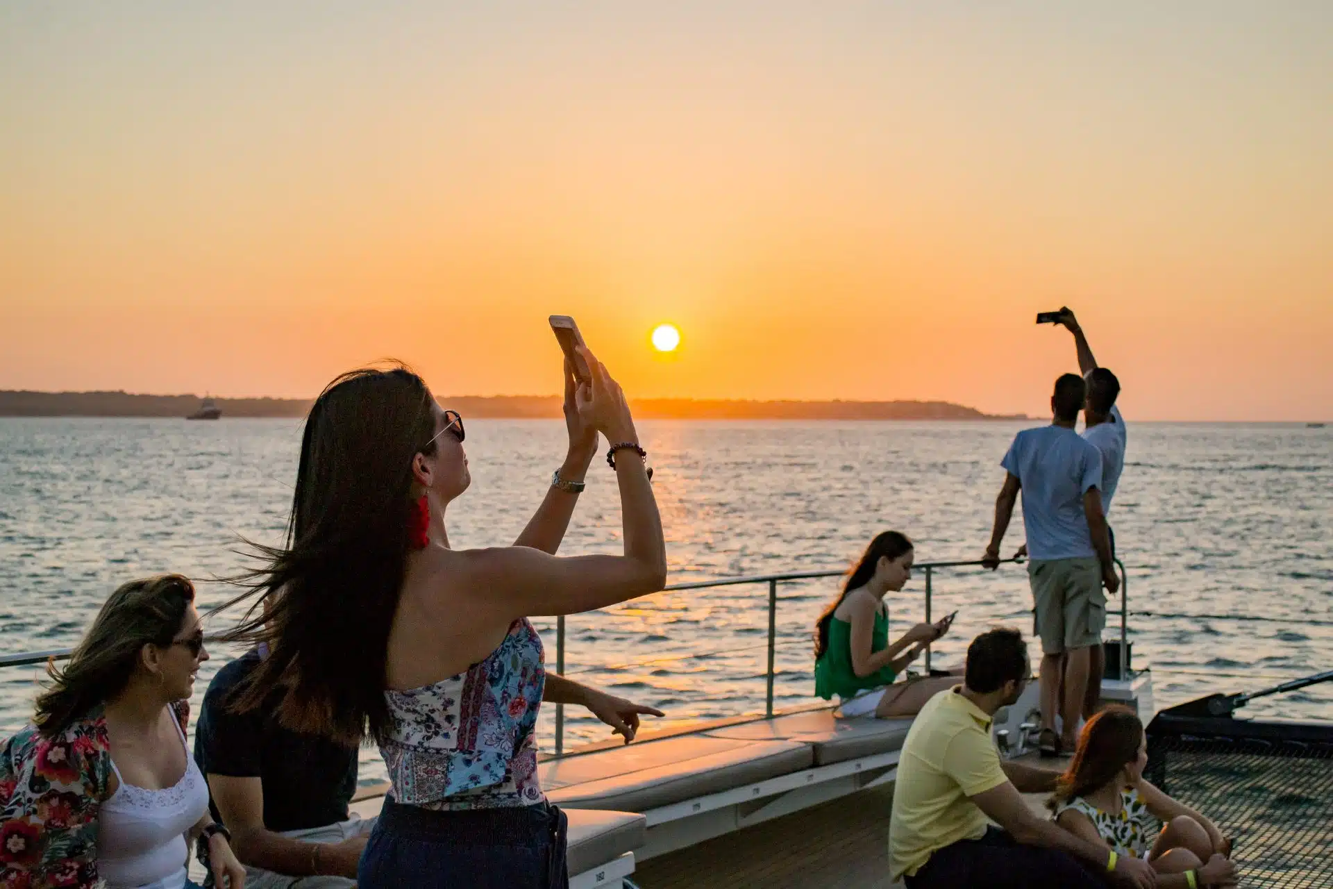 Guests enjoying the ocean breeze and sunset views on a cartagena sunset boat tour private experience.