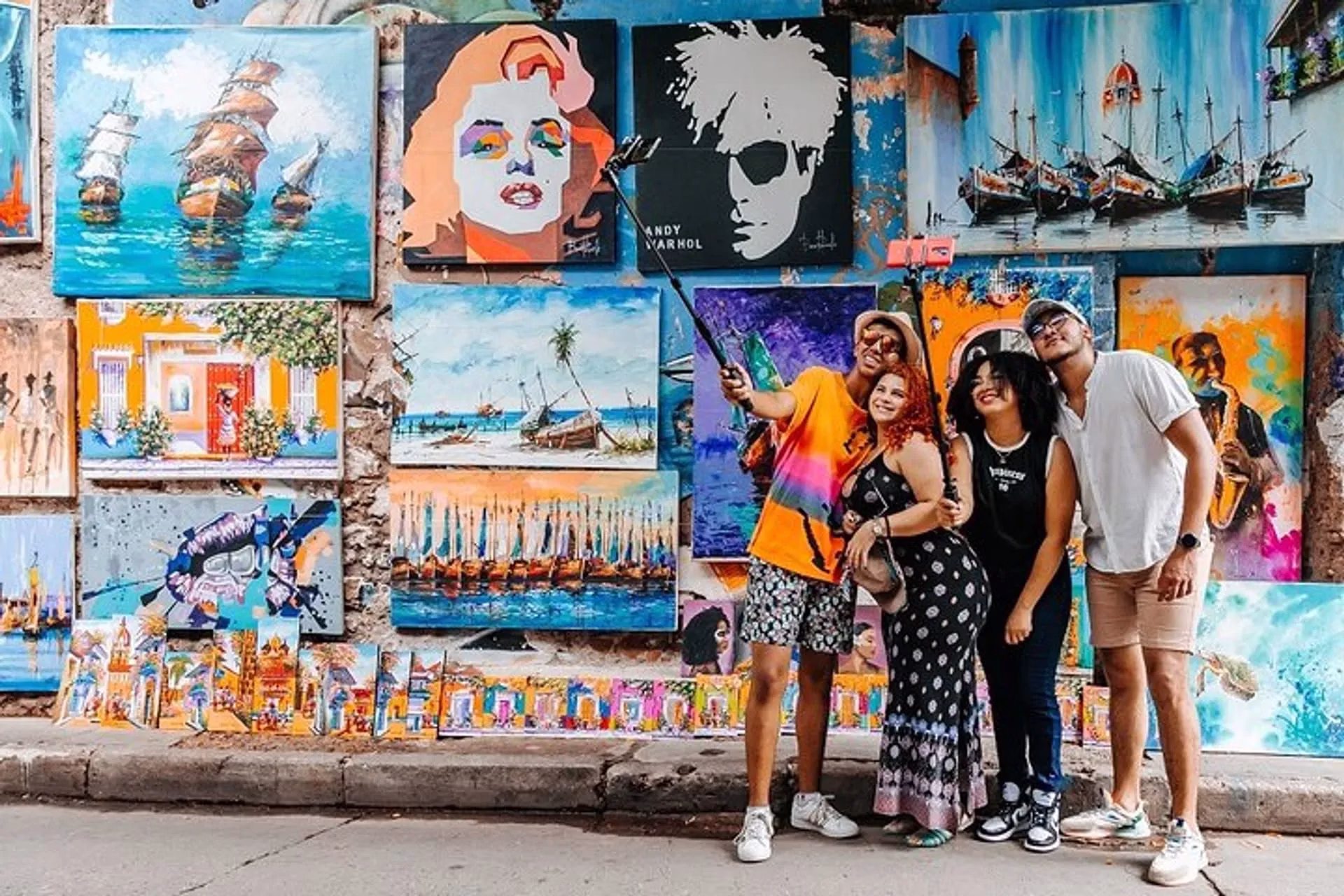 Travelers taking a selfie in front of colorful street art during a Graffiti Tour in Cartagena, Colombia