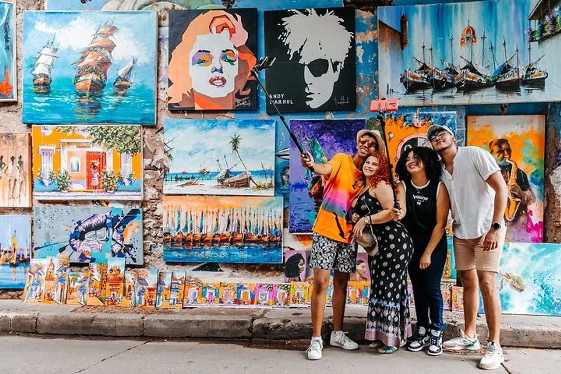 Travelers taking a selfie in front of colorful street art during a Graffiti Tour in Cartagena, Colombia