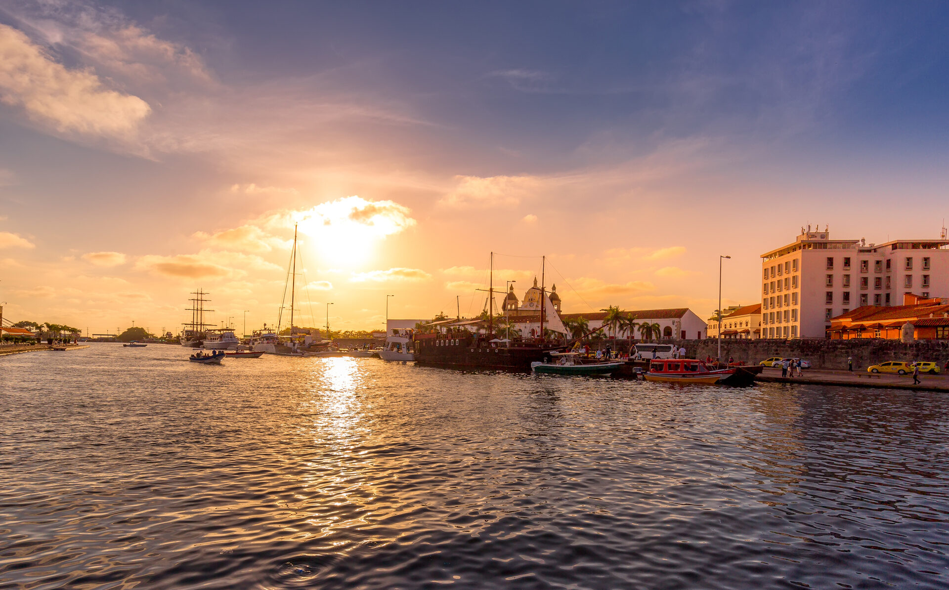 Golden sunset over Cartagena Bay with boats and skyline views during a cartagena sunset boat tour private.