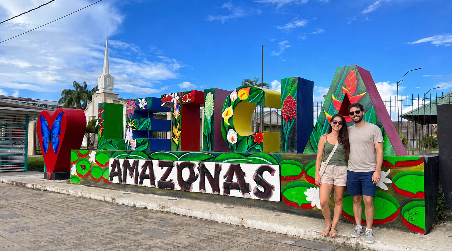 Couple posing beside the colorful Leticia Amazonas sign during a City tour Leticia Tabatinga.