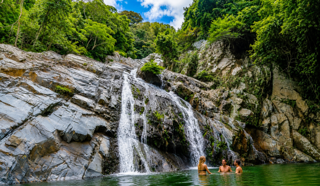 Travelers bathing in a crystal-clear waterfall pool during a La Guajira waterfall tour.