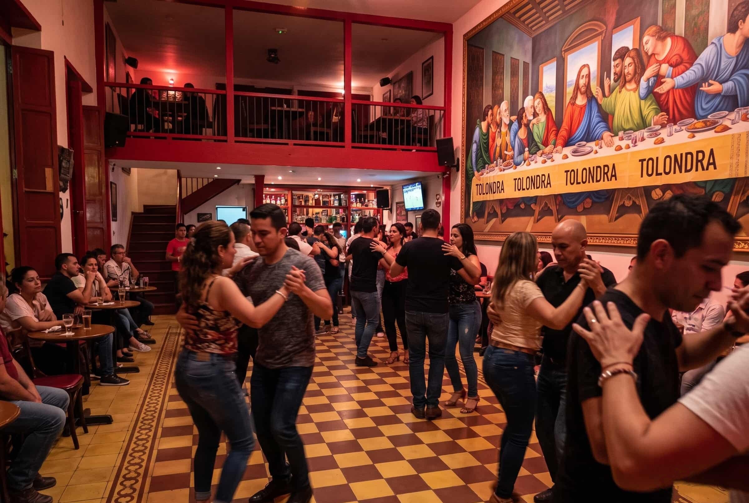 Couples dancing salsa in a colourful club in Cali