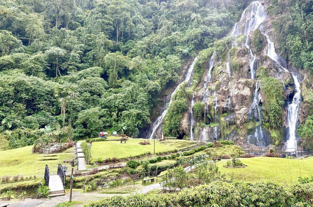 Scenic landscape of the waterfall and walking paths at Santa Rosa de Cabal hot springs in the middle of tropical nature.